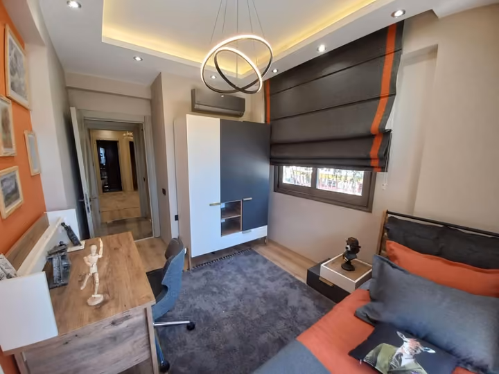 A show apartment single bedroom with a study desk and built-in storage.