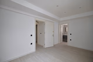 Unfurnished room with doors to the hallway and adjoining bathroom.
