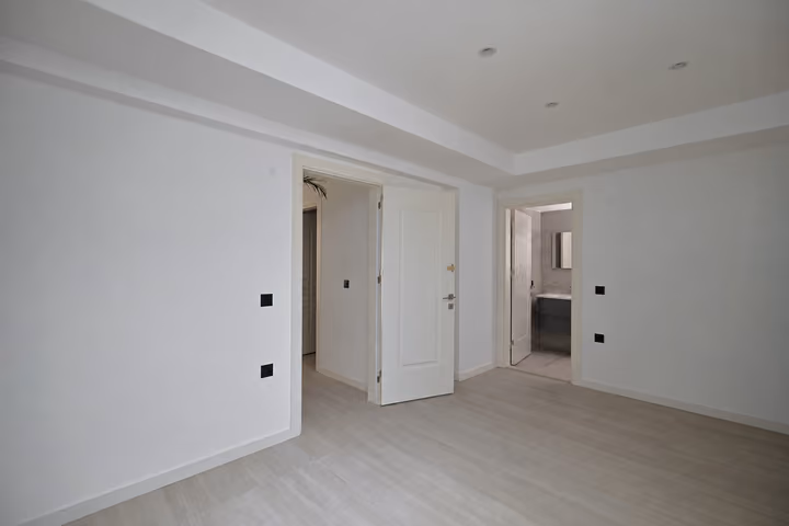 Unfurnished room with doors to the hallway and adjoining bathroom.
