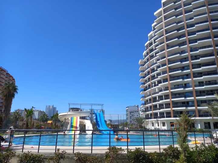 The shared outdoor pool and water slides beside the residential buildings.