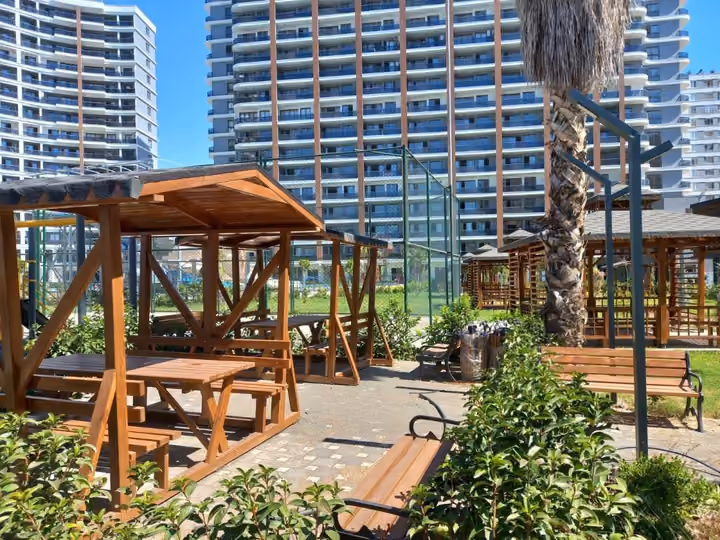 Wooden gazebos and shaded seating in the landscaped residential grounds.