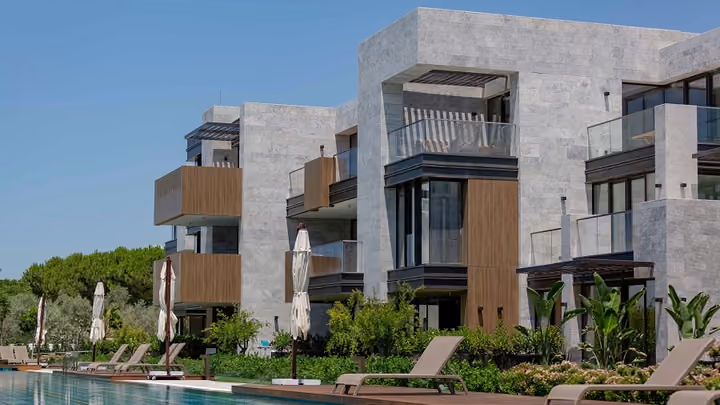 Stone clad apartments with recessed balconies in Boyalik, Cesme.
