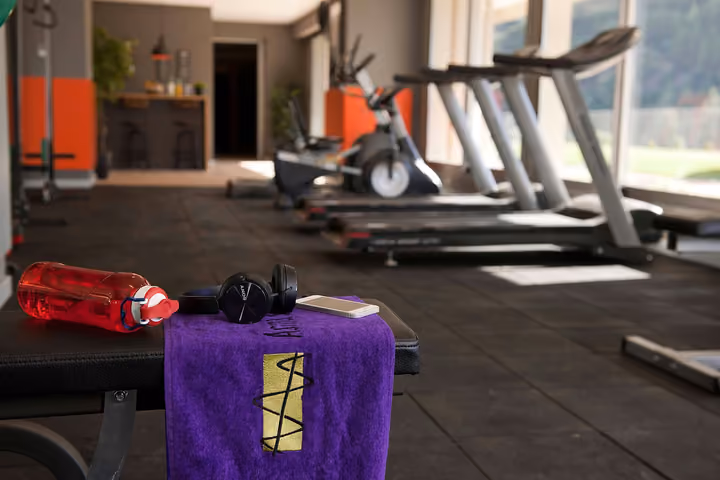 Fitness room with cardio machines and training equipment.