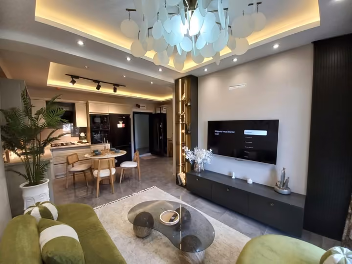 A furnished show apartment living and dining area with a media wall.