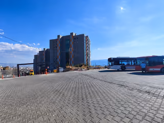 Paved outdoor plaza beside a residential tower.