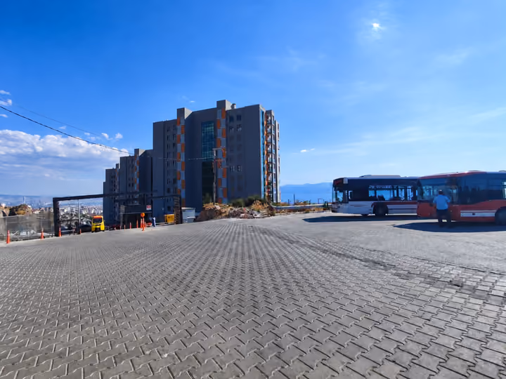 Paved outdoor plaza beside a residential tower.