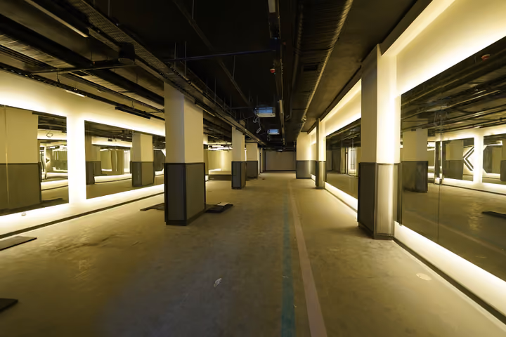 Wide mirrored interior intended for fitness use, photographed without exercise equipment during finishing work. Source photograph dated 22 July 2026.