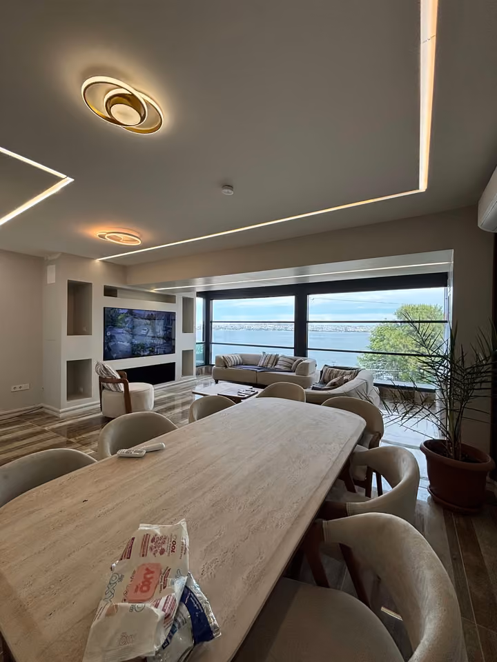 Wide view of the dining table and living room overlooking the sea.