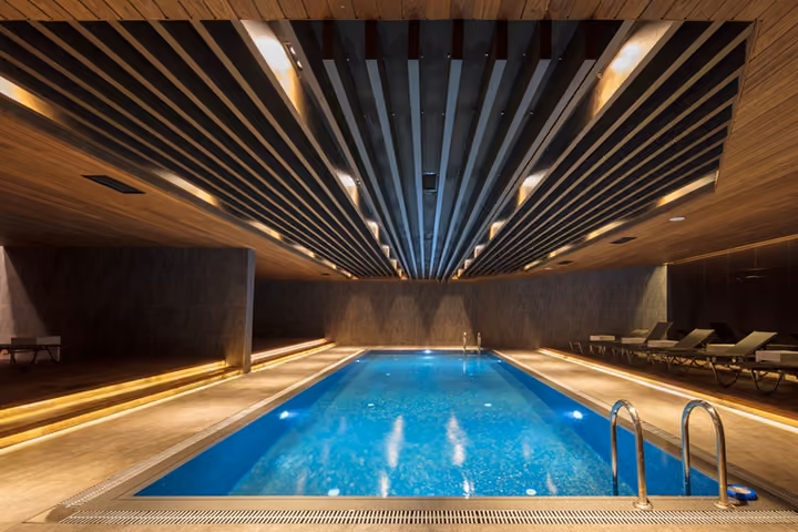 Indoor swimming pool with loungers.
