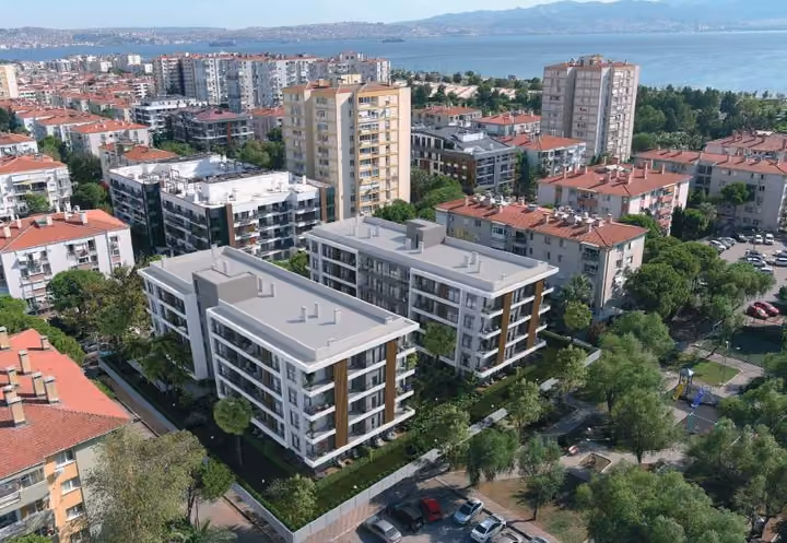 Architectural visualization of two apartment blocks in their urban surroundings, with the Izmir waterfront in the distance.